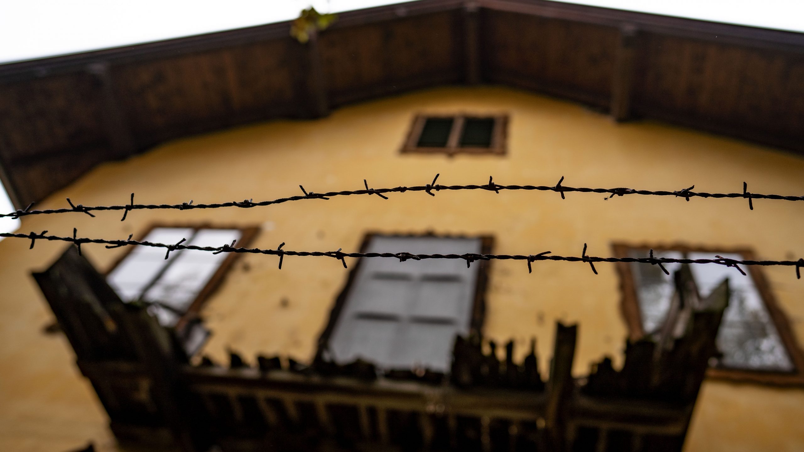 barbed wire overlooking a yellow house