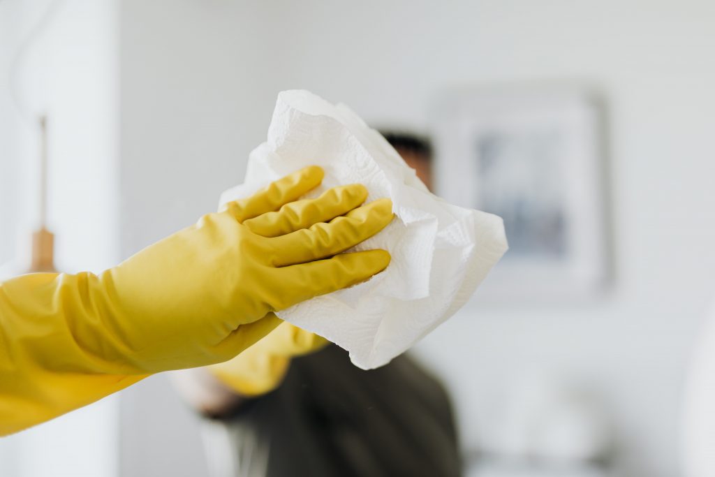 hand with yellow gloves holding tissue