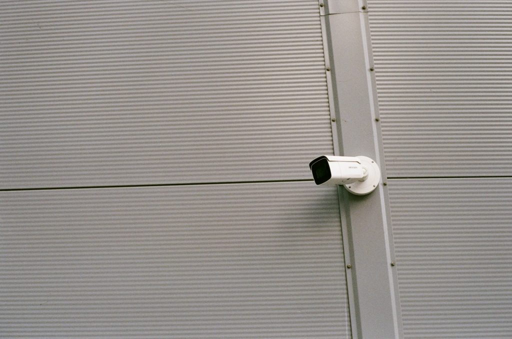 white security camera mounted on brown wall